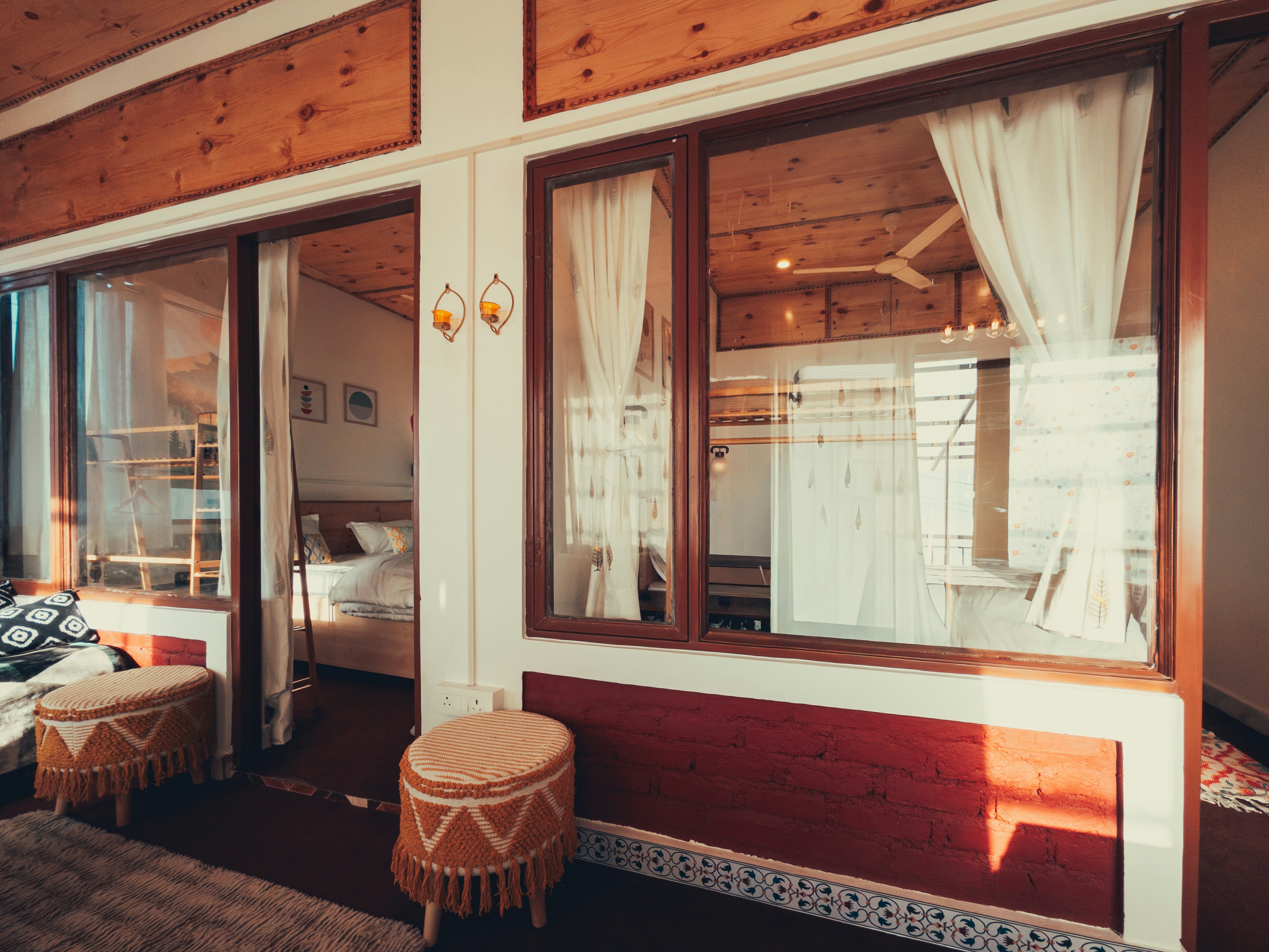 Bright guest room with large windows and warm wooden details